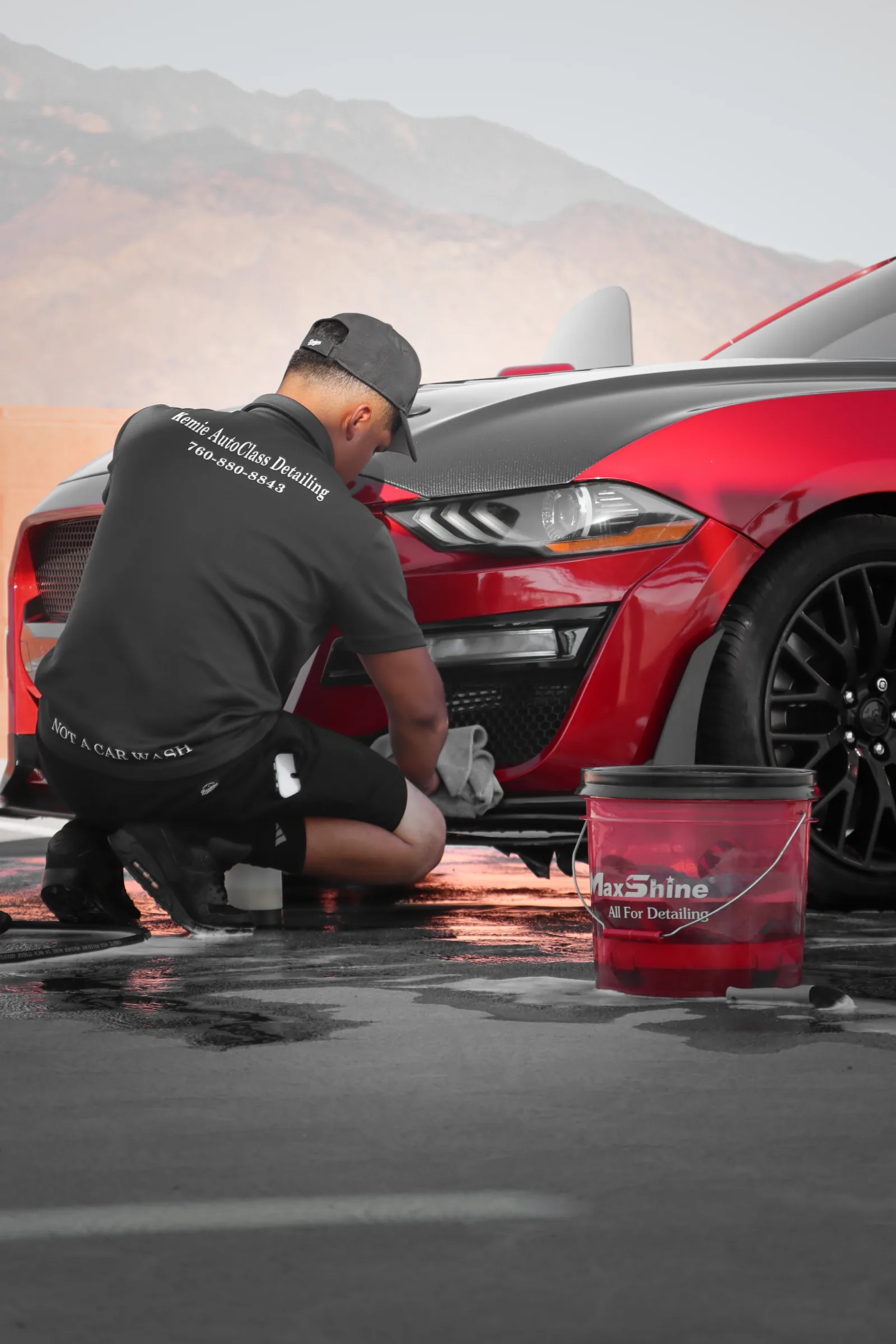 Kemie AutoClass detailer carefully cleaning a red performance vehicle