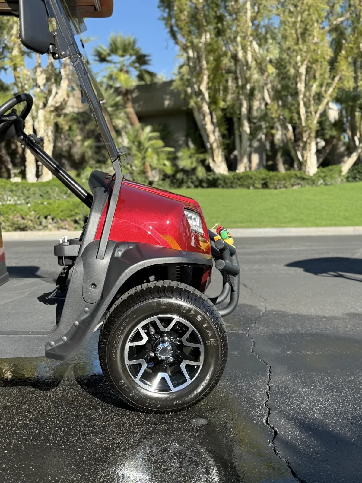 Clean front wheel and bodywork on a red golf cart