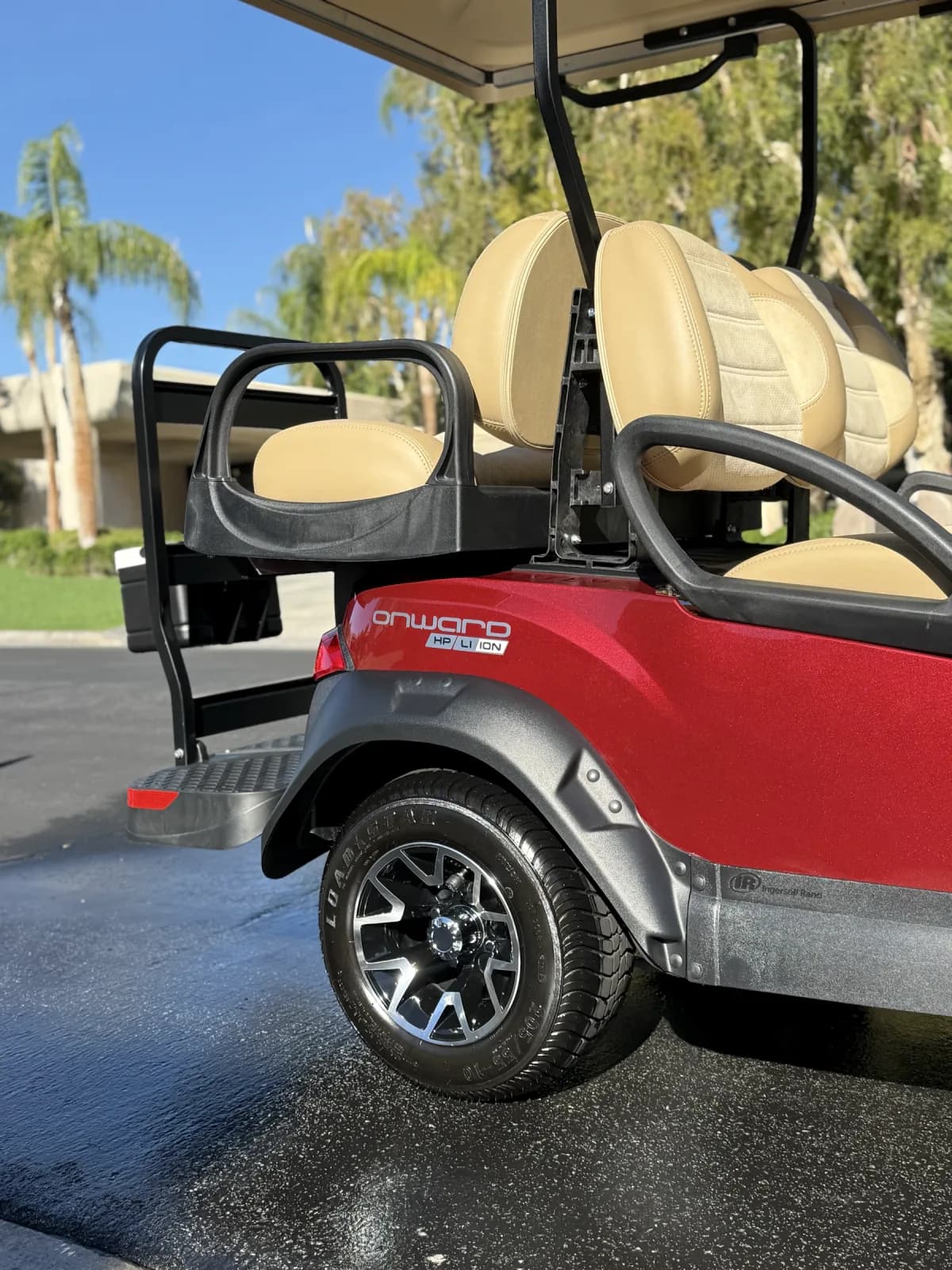 Detailed rear wheel, bodywork and seating on a red golf cart